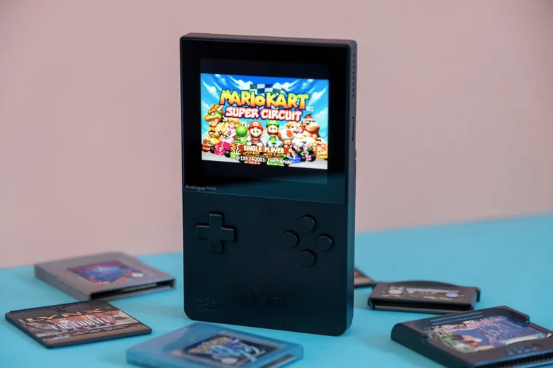 An image of the console on a table surrounded by games. 