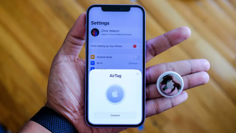 A phone and a tag and a hand.