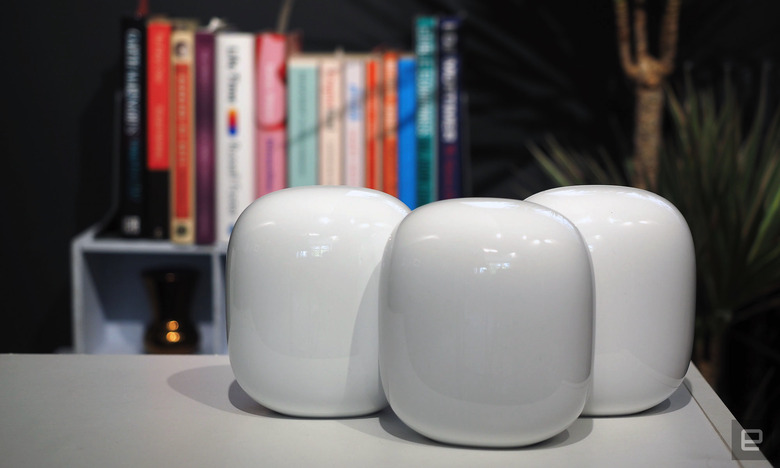 Image of three Nest WiFi Pro units on a table in front of a blurred bookshelf.