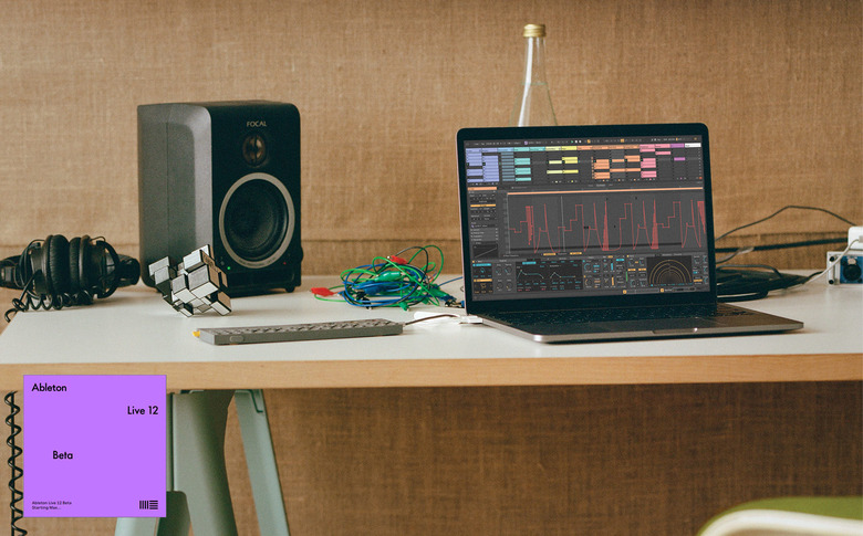 A laptop running Ableton Live 12 alongside a portable synth and a desktop monitor speaker.