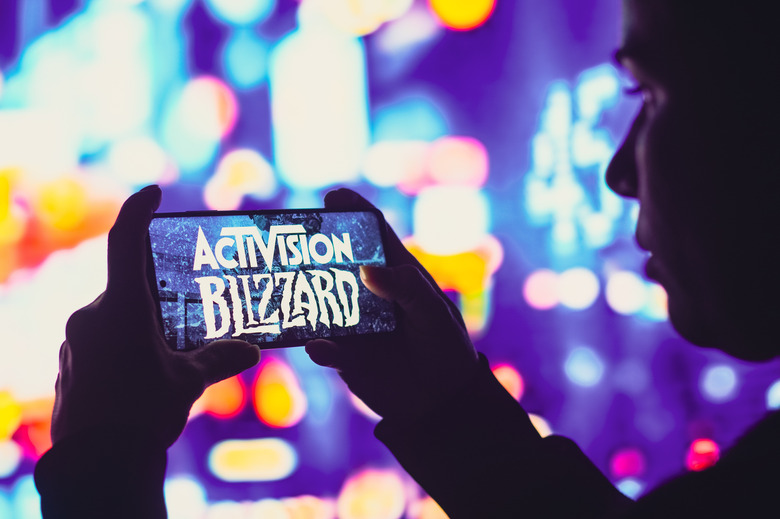 BRAZIL - 2022/06/01: In this photo illustration, a silhouetted woman holds a smartphone with the Activision Blizzard, Inc. logo displayed on the screen. (Photo Illustration by Rafael Henrique/SOPA Images/LightRocket via Getty Images)
