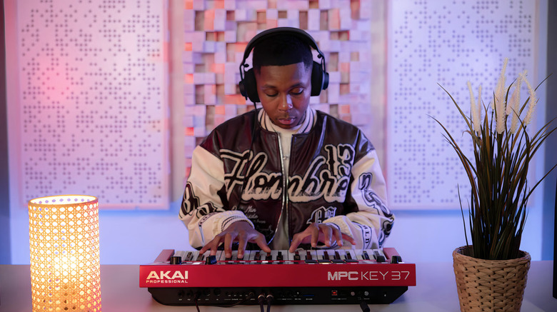 A man playing the keyboard with headphones on.