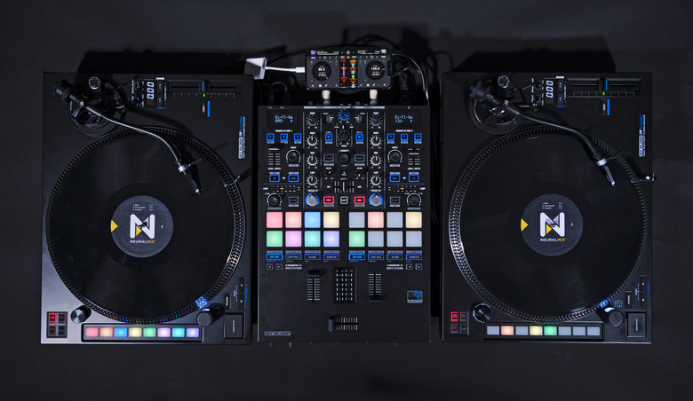 An overhead view of a DJ setup showing two turntables with control discs on them alongside a Reloop DJ mixer and an iPhone which now supports a digital vinyl system (DVS). 