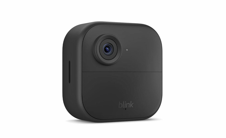 A square Blink Outdoor 4 camera in black with rounded edges seen against a white background. 