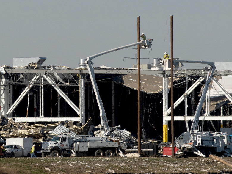 Amazon crew on lifts document the damage from the tornado that hit an Amazon distribution centre where the roof collapsed in Edwardsville, Illinois, U.S. December 13, 2021.  REUTERS/Lawrence Bryant