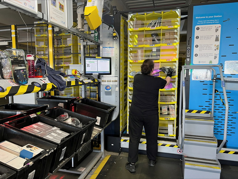 An Amazon worker places a product on a shelf for storage, at an Amazon warehouse, which opened in August 2021, in Dartford, Kent, Britain May 3, 2023. REUTERS/Helen Reid