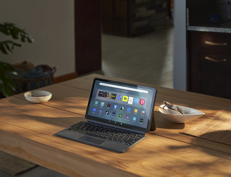 The Fire Max 11 tablet propped up by the kickstand on the back of its case, with a keyboard in front of the screen.