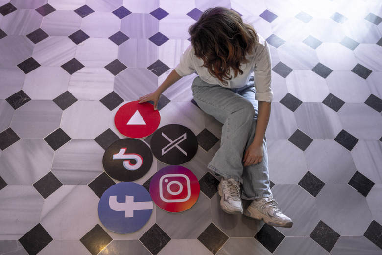ISTANBUL, TURKIYE - JUNE 08: A woman sits next to the banners of TikTok, Facebook, Youtube, Instagram and X in Istanbul, Turkiye on June 08, 2024. (Photo by Didem Mente/Anadolu via Getty Images)
