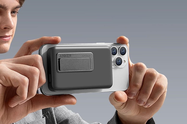 Anker 633 MagSafe-enabled charger attached to an iPhone that someone is holding as if they're framing a photo.