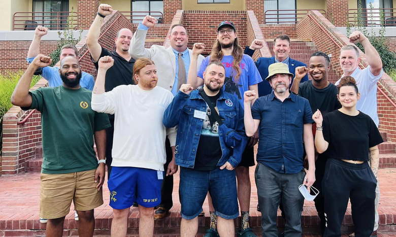 Workers from the Towson, Maryland Apple Store union stand in front of brick stairs