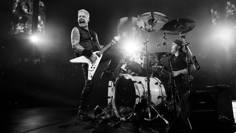Black and white image of James Hetfield and Lars Ulrich on stage during a Metallica concert.