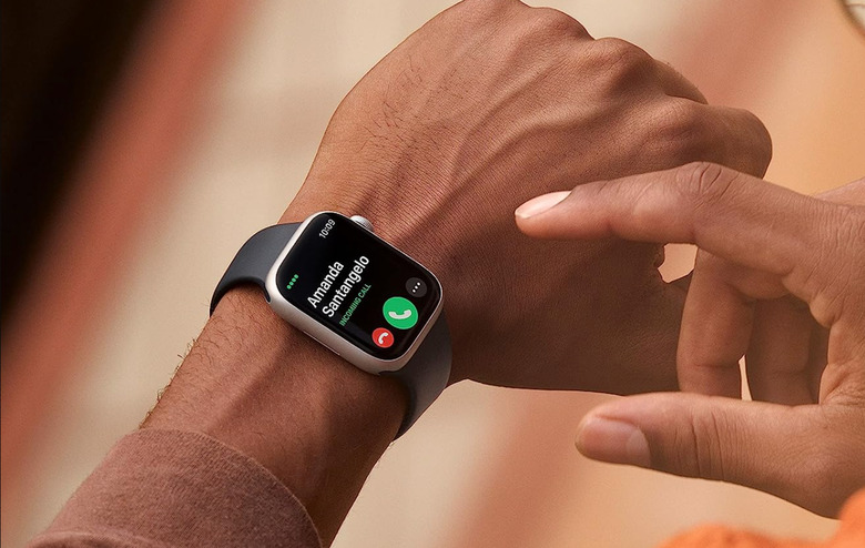 A hand fiddling with the Apple Watch 8.