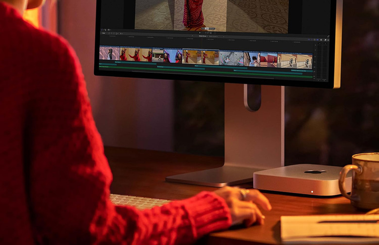 A person sitting in front of an Apple computer.