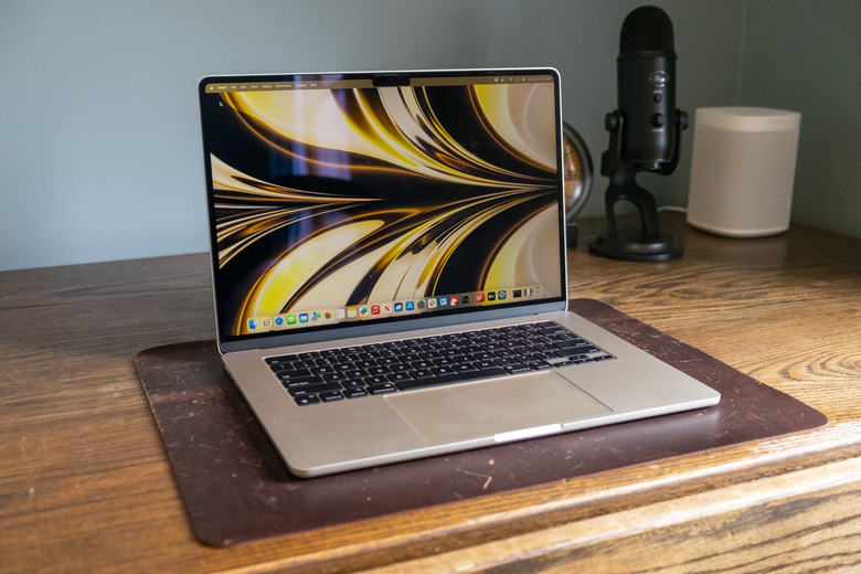 A laptop on top of a wooden desk.