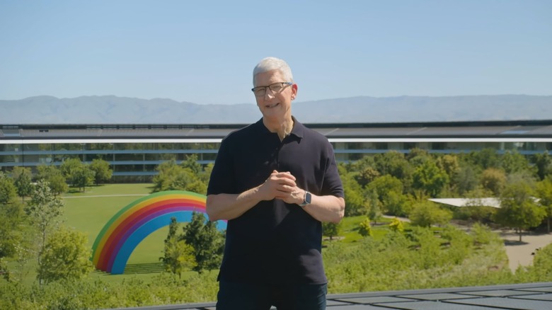 Video still of Tim Cook standing atop Apple Park. A rainbow structure is visible on the ground behind.