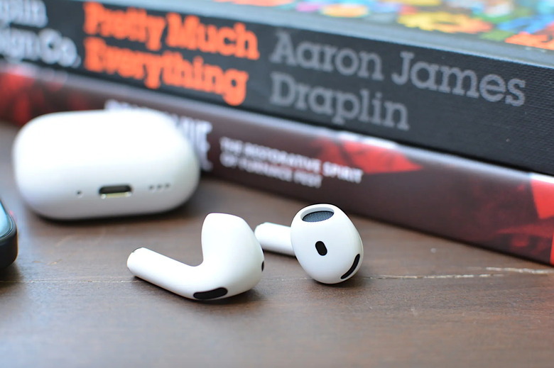 Some earbuds in front of books.