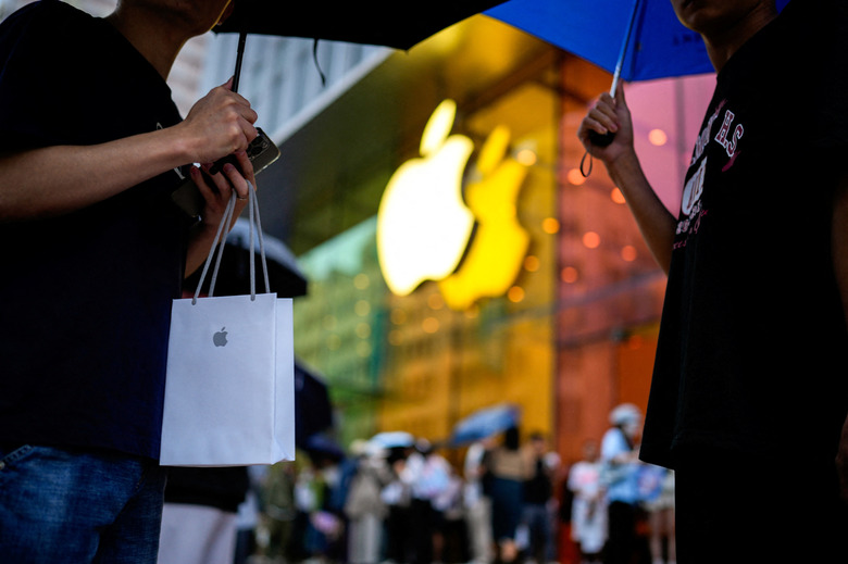 A man holds a bag with a new iPhone inside as Apple's new iPhone 15 officially goes on sale across China, next to an Apple Store, in Shanghai, China September 22, 2023. REUTERS/Aly Song