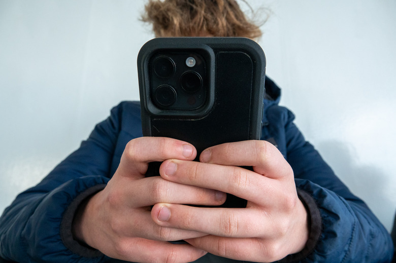 PORTSMOUTH, UNITED KINGDOM - OCTOBER 20: A 14-year-old boy looks at a iPhone screen on October 20, 2024 in Portsmouth, England. The amount of time children spend on screens each day rocketed during the Covid pandemic by more than 50 per cent, the equivalent of an extra hour and twenty minutes. Researchers say that unmoderated screen time can have long-lasting effects on a child's mental and physical health. Recently TikTok announced that every account belonging to a user below age 18 have a 60-minute daily screen time limit automatically set. (Photo by Matt Cardy/Getty Images)