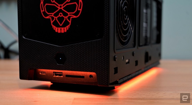 A photo of a black computer case with a skull design on top of a wooden table.