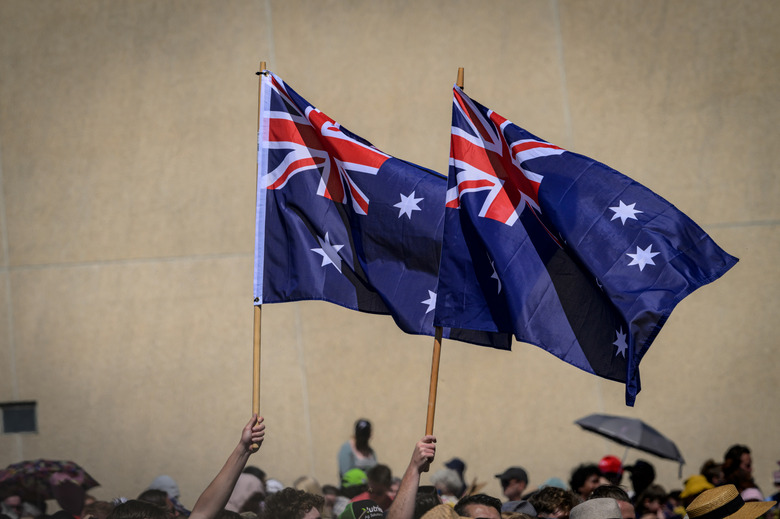 CANBERRA, AUSTRALIA - 2024/10/21: Royals' supporters are seen holding two Australian national flags. King Charles and Queen Camilla received a ceremonial welcome from the Australian troops and met with members of the public at the Parliament House forecourt in Canberra. Their Majesties will be in Australia from 18 to 23 October 2024, marking King Charles's first visit to Australia as Sovereign. (Photo by George Chan/SOPA Images/LightRocket via Getty Images)
