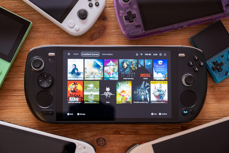 The Ayaneo Kun gaming handheld is pictured surrounded by many rival gaming handhelds.