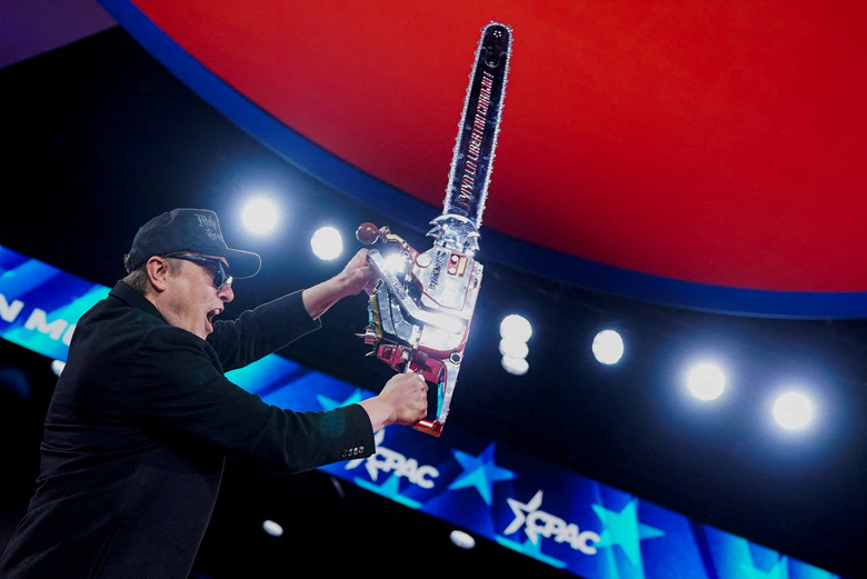 Elon Musk holds up a chainsaw onstage during the Conservative Political Action Conference (CPAC) in National Harbor, Maryland, U.S., February 20, 2025. 