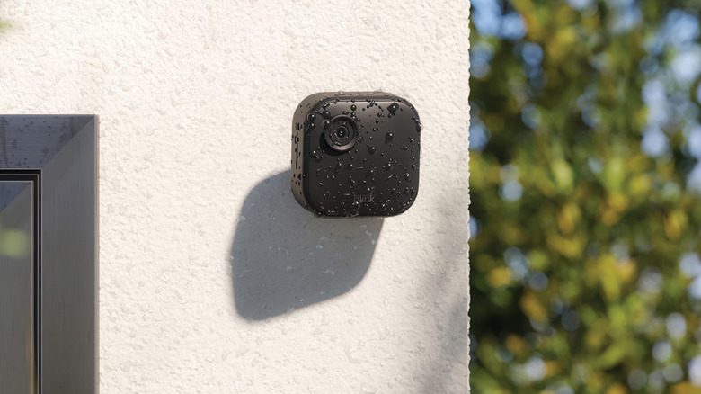 The Blink Outdoor 4 security camera mounted on an outdoor home wall.
