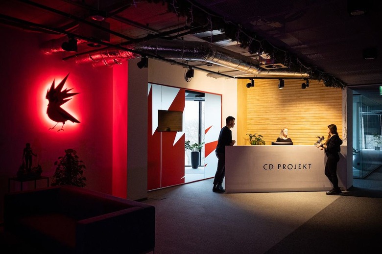 A front desk at CD Projekt Red on the right and the bird logo on the left. 