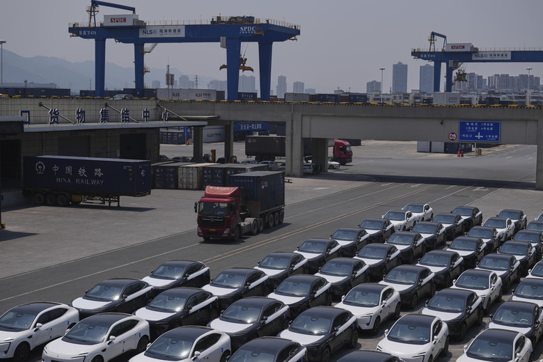 A truck moves by Changan's Avatr car models waiting for shipment at a logistics center near the Chongqing Railway Container Terminal Station, in southwest China's Chongqing Municipality on Tuesday, May 20, 2025. (AP Photo/Andy Wong)