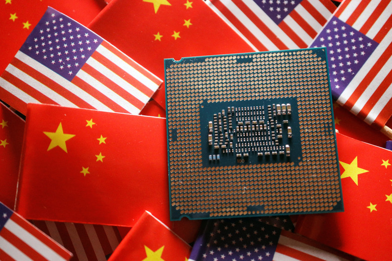 FILE PHOTO: A central processing unit (CPU) semiconductor chip is displayed among flags of China and U.S., in this illustration picture taken February 17, 2023. REUTERS/Florence Lo/Illustration/File Photo