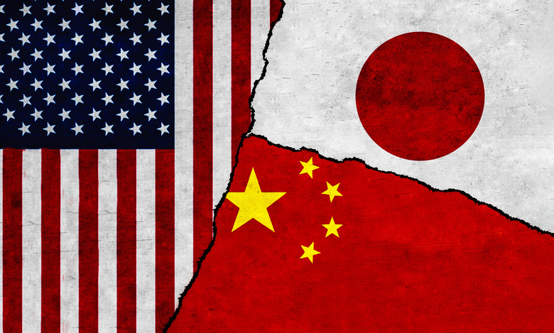 USA, Japan and China flags on wall with crack. Japan, United States of America and China conflict