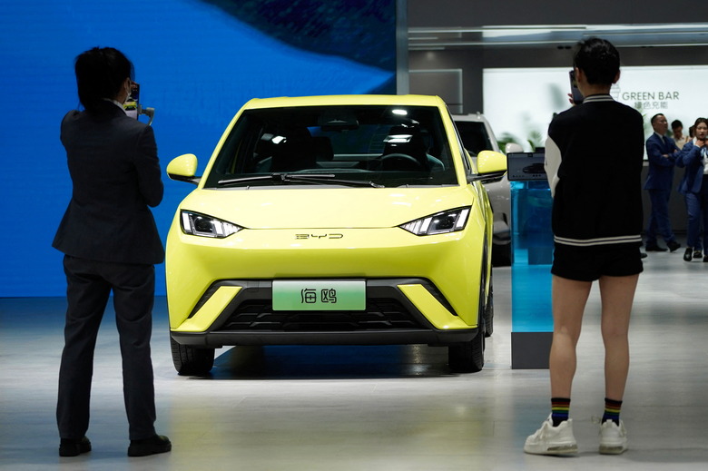 People use their phones in front of the BYD Seagull that is displayed at the Auto Shanghai show, in Shanghai, China April 19, 2023. REUTERS/Aly Song