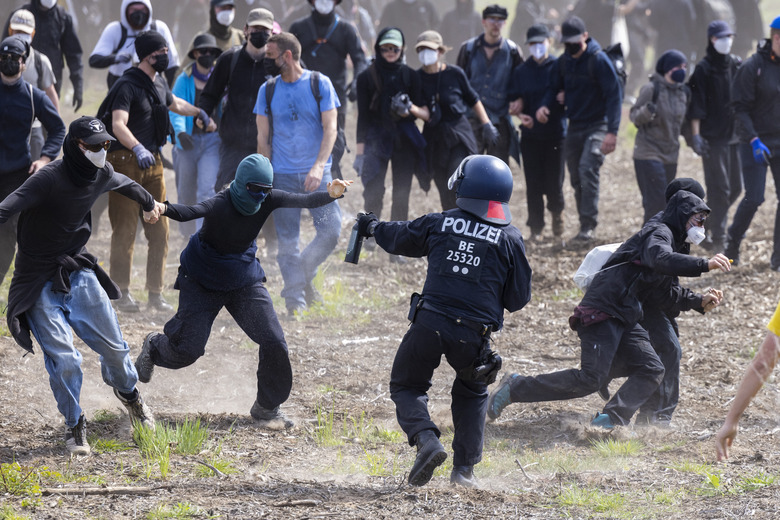 GRUENHEIDE, GERMANY - MAY 10: Police confront environmental activists in a forest near the Tesla Gigafactory electric car factory on May 10, 2024 near Gruenheide, Germany. Activists have come from across Germany to demand a stop to plans by Tesla to expand the factory, which would involve cutting down at least 50 hectares of trees. Some locals also support the protest, citing stress to local groundwater reserves from the factory. (Photo by Axel Schmidt/Getty Images)