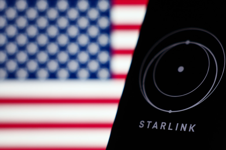 American flag displayed on a laptop screen and Starlink logo displayed on a phone screen are seen in this illustration photo taken in Krakow, Poland on March 11, 2025. (Photo by Jakub Porzycki/NurPhoto via Getty Images)