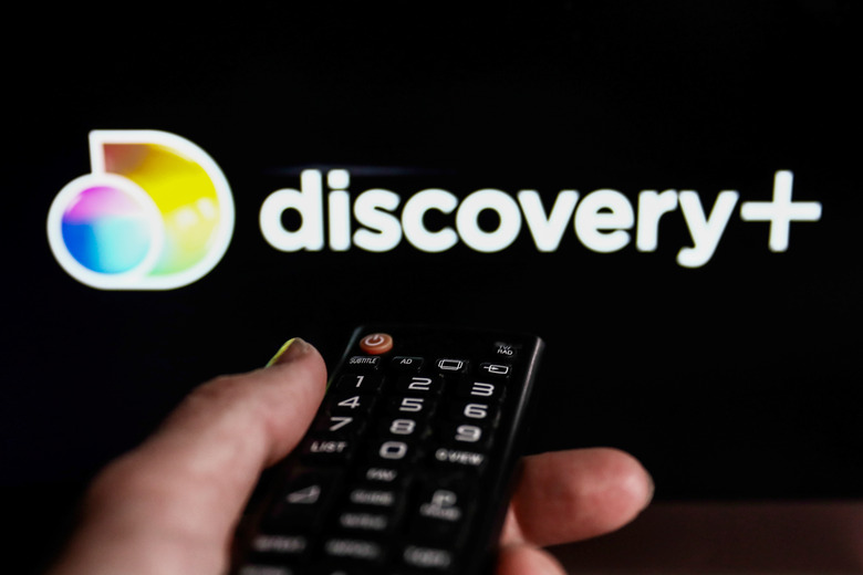TV remote control and Discovery+ logo displayed on a laptop screen are seen in this illustration photo taken in Krakow, Poland on February 9, 2022. (Photo illustration by Jakub Porzycki/NurPhoto via Getty Images)