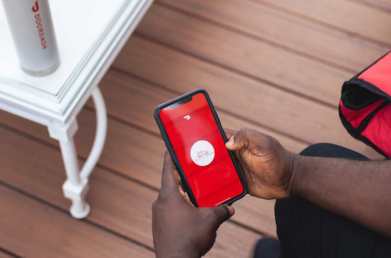 A person holding a phone with the DoorDash app open.