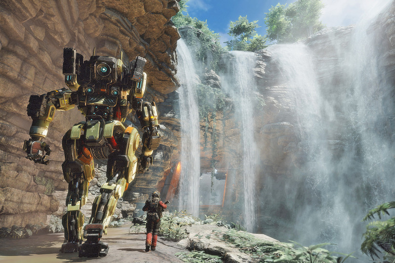 A mechanoid robot and a human walk towards a large rocky waterfall in this image from the video game 'Titanfall 2'.