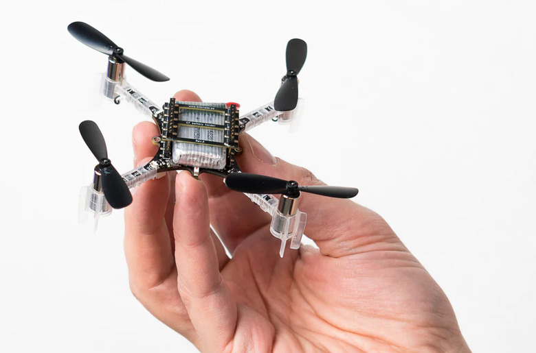 Photo of a hand holding a small quadcopter drone.