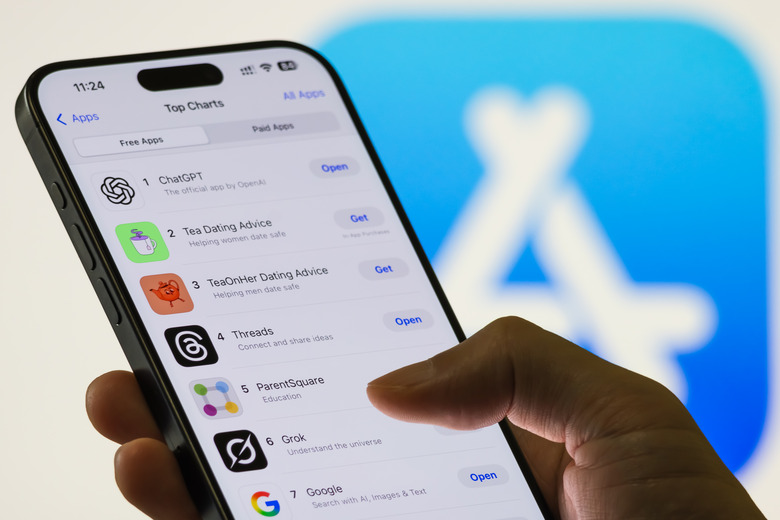 CHONGQING, CHINA - AUGUST 12: In this photo illustration, a person uses a smartphone showing the Apple App Store top charts with ChatGPT ranked as the number one free app, followed by other popular applications including Grok, on August 12, 2025 in Chongqing, China. (Photo illustration by Cheng Xin/Getty Images)