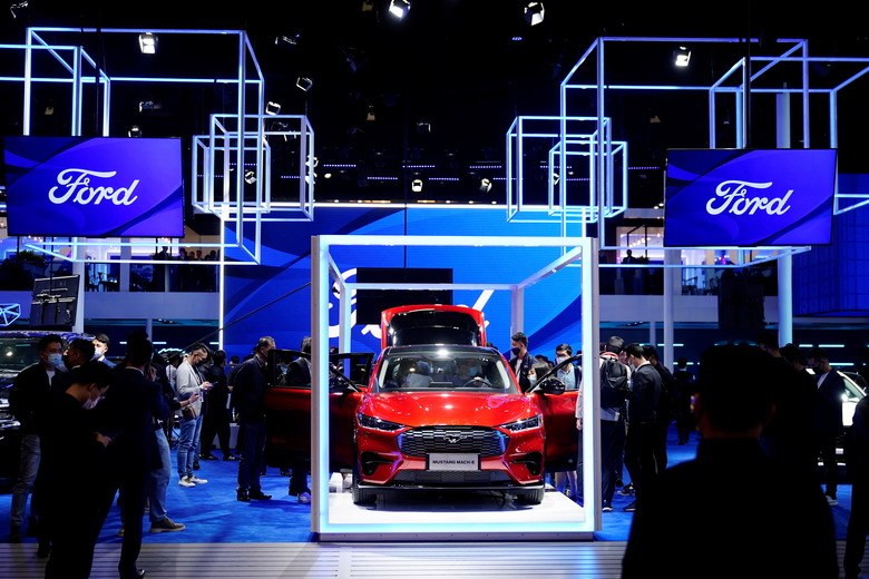 Visitors check a Ford Mustang Mach-E electric vehicle (EV) displayed at the Ford booth during a media day for the Auto Shanghai show in Shanghai, China April 19, 2021. REUTERS/Aly Song