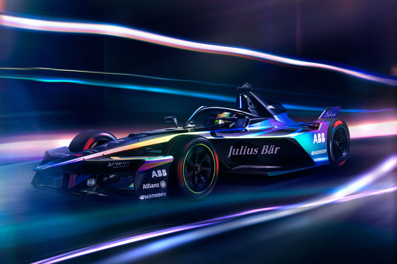 Formula E Gen3 Evo race car in motion with blurred lights all around it. 