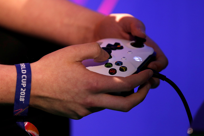 A player holds his gaming controller as he  competes in the FIFA 2018 eClub World Cup qualifiers in Paris, France, May 19, 2018. REUTERS/Philippe Wojazer