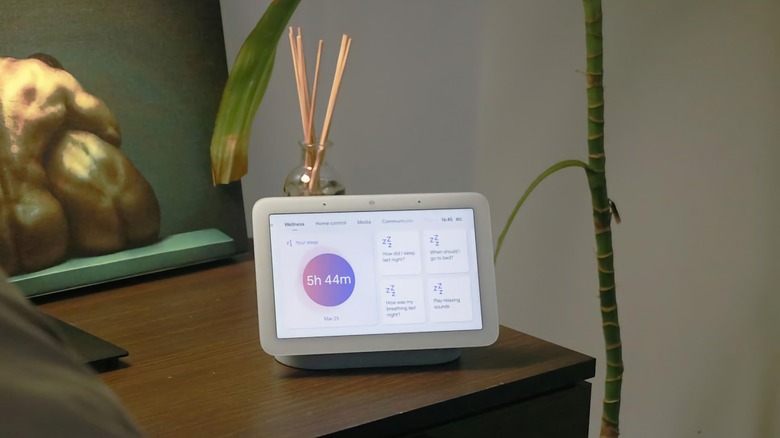 A second-generation Google Nest Hub sitting on a nightstand.