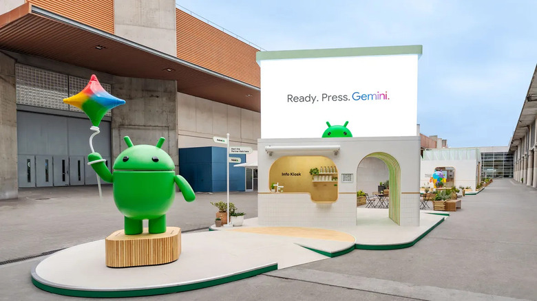 The Android mascot stands in front of a Gemini AI kiosk in Barcelona. 