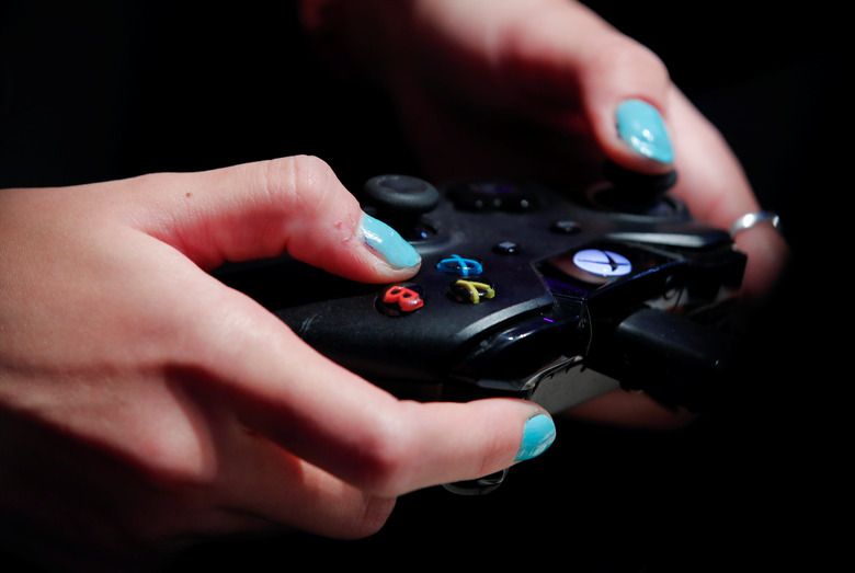 A female gamer uses an XBox One game controller to play Need for Speed, at the world's largest computer games fair, Gamescom, in Cologne, Germany August 23, 2017. REUTERS/Wolfgang Rattay