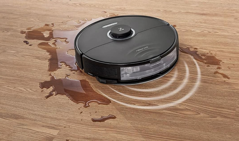 A robot vacuum and mop cleaning up some liquid on a floor.