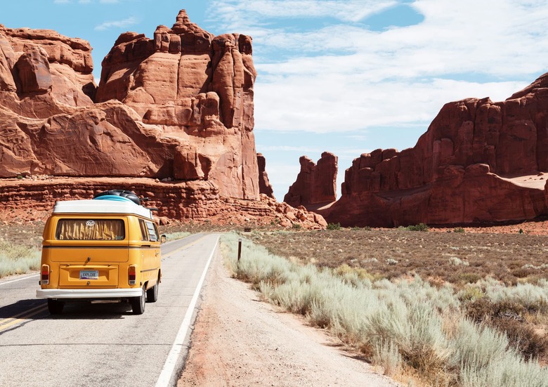 A camper van travels along a desert road