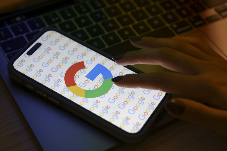 ANKARA, TURKIYE - DECEMBER 07: A mobile phone screen displays the Google logo with a laptop in the background in Ankara, Turkiye on December 07, 2023. (Photo by Dilara Irem Sancar/Anadolu via Getty Images)