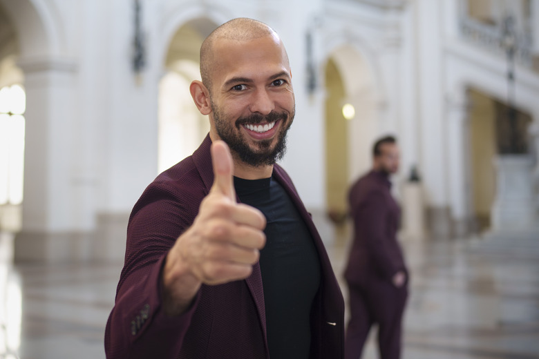 FILE - Andrew Tate poses giving a thumbs up upon arriving with his brother Tristan, right, at the Court of Appeals building in Bucharest, Romania, Tuesday, Oct. 15, 2024. (AP Photo/Vadim Ghirda, File)