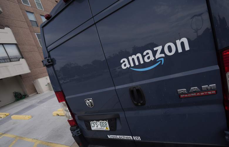 The company logo graces one of the doors of a delivery van for Amazon Wednesday, Sept. 1, 2021, in Denver. A labor organizer says more than 60 Amazon workers across three delivery stations staged a walkout on Wednesday, March 16, 2022, to demand a $3 raise and a return to 20-minute breaks. (AP Photo/David Zalubowski)